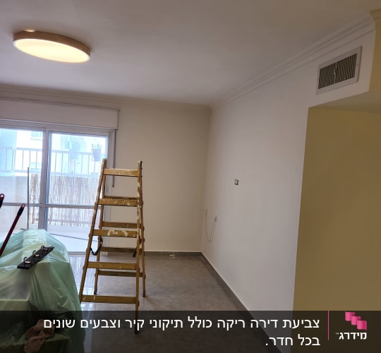 סולם וחומרי צביעה בחדר ריק עם קירות צבועים